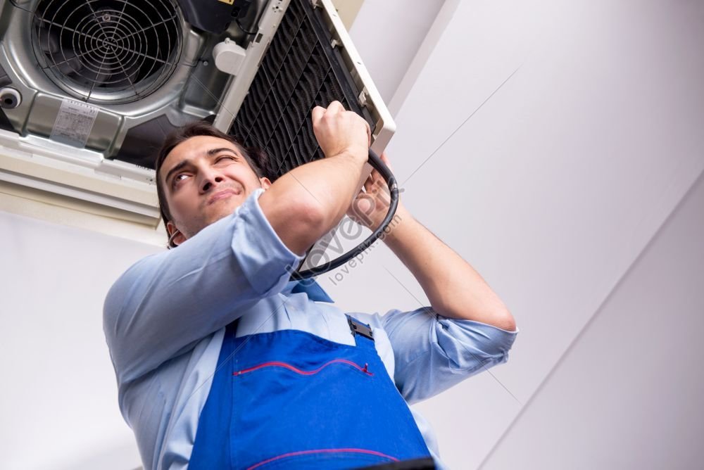 Young Repairman Working On Air Conditioning Unit On Ceiling Photo ... Young Repairman Working On Air Conditioning Unit On Ceiling Photo ...